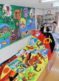 東京五輪の公式ＨＰに掲載された作品と塩飽康正さん（左）、隆子さん夫妻＝赤穂市大町