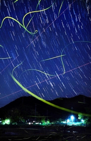 星の隙間を縫うように舞うゲンジボタル（５月３０日夜、８秒露光の写真１３０枚を比較明合成）＝猪名川町内