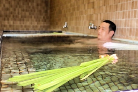 ショウブの束を浮かべた湯船＝都湯