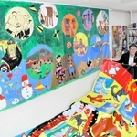 東京五輪の公式ＨＰに掲載された作品と塩飽康正さん（左）、隆子さん夫妻＝赤穂市大町