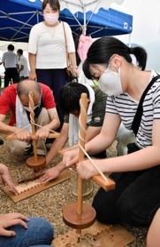 たつの市では参加者が「きりもみ式」で種火づくりに挑んだ＝同市新宮町新宮