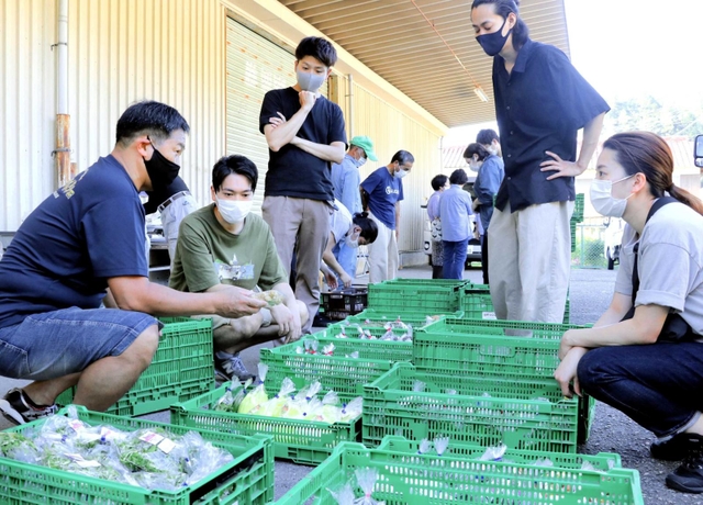 集荷場を訪れ、日頃購入している野菜の生産者から話を聞くシェフら＝佐用町豊福