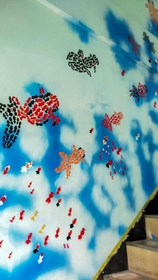 地元の画家、千崎輝幸さんが階段の壁に描いた金魚の絵＝赤穂市加里屋