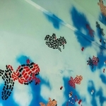 地元の画家、千崎輝幸さんが階段の壁に描いた金魚の絵＝赤穂市加里屋