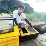 捕まえた山本英雄さん。ウナギ釣りが趣味で、手にしているいけすに入れて用水路で飼っている＝たつの市揖保川町袋尻