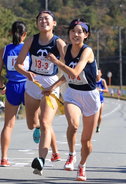 女子・龍野の３区村下綺菜選手（左）からたすきを受け取る４区宝谷芽依選手＝丹波篠山市内（撮影・吉田敦史）