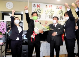 花束を手に初当選を喜ぶ住吉寛紀氏＝姫路市小姓町