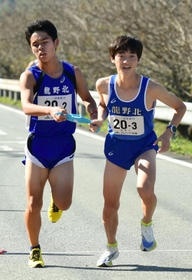 男子・龍野北の２区石田楓真選手（左）からたすきを受け取る３区東虎汰朗選手＝丹波篠山市内（撮影・坂井萌香）
