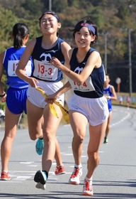 女子・龍野の３区村下綺菜選手（左）からたすきを受け取る４区宝谷芽依選手＝丹波篠山市内（撮影・吉田敦史）