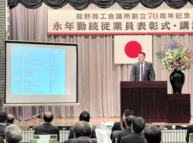 記念式典で講演する真鍋政義さん＝龍野経済交流センター