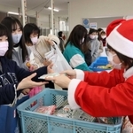サンタクロース姿の職員から食品を受け取る学生ら＝相生市看護専門学校