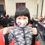 切ったばかりの髪を手にする横田凛さん＝姫路市網干区垣内北町