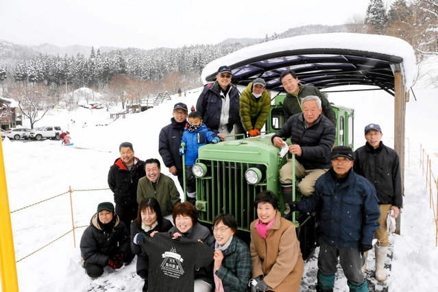 展示中のディーゼル車を笑顔で囲む「波賀元気づくりネットワーク協議会」のメンバー。撮影日は一面の雪となった＝フォレストステーション波賀（撮影・大山伸一郎）