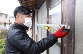 依頼を受けて物干しざおの高さを調整する渡部政弘さん＝相生市川原町