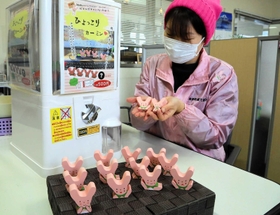カプセルトイ販売機「ひょっこりカーミン」とカーミンの置物＝神河町観光協会