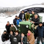 展示中のディーゼル車を笑顔で囲む「波賀元気づくりネットワーク協議会」のメンバー。撮影日は一面の雪となった＝フォレストステーション波賀（撮影・大山伸一郎）