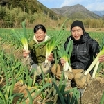 山あいの畑で収穫したまちこネギをＰＲする東勇太さん（右）と永瀬静さん＝市川町上牛尾