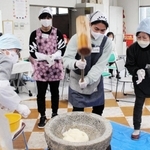 きねを力強く振りかざし餅をつく外国人ら＝相生市旭３