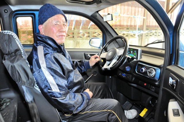 小型電気自動車に乗る本林俊昭さん。まひのない左側の手足を使い、運転する＝上郡町船坂