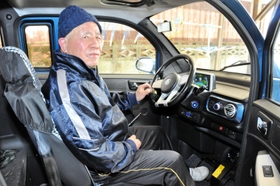 小型電気自動車に乗る本林俊昭さん。まひのない左側の手足を使い、運転する＝上郡町船坂