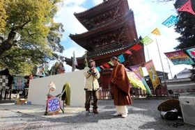 斑鳩寺の大谷康文住職（右）と並んであいさつするスズキコージさん＝太子町鵤