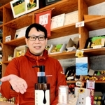 ヒマワリ油を使ったスキンケア商品「さようのめぐみ」と、商品化を企画した平福祐介さん＝南光ひまわり館