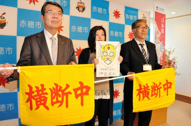 寄贈された横断旗を持つ牟礼正稔市長（左）ら＝赤穂市役所