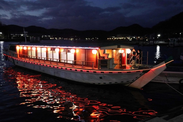 赤いちょうちんの明かりが夜の海面に揺れる屋形船＝相生市内