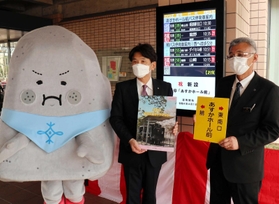 町キャラクター「ぼうじぃ」と並んでバス停をＰＲする服部千秋町長（中央）と神姫バスの橋本友一・山崎出張所長＝太子町鵤