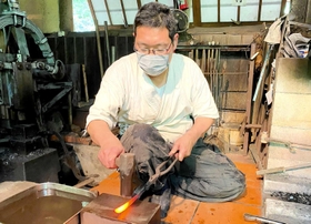 手鎚を振るい、小刀の形をつくる桔梗隼光さん＝相生市矢野町瓜生羅漢口