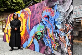 空から降臨する竜の天井画を迫力満点に描いた不動貴雄さん＝安志加茂神社