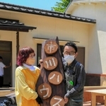 「市川ハウス」の看板と並ぶ市川さん（右）と和田さん＝市川町下牛尾