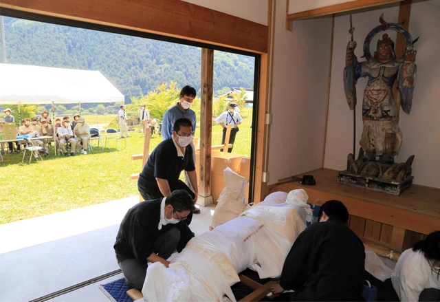 住民が見守る中、運び出される毘沙門天＝神河町長谷