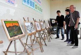本林俊昭さん（右）の切り絵作品が並ぶ会場＝上郡ピュアランド山の里