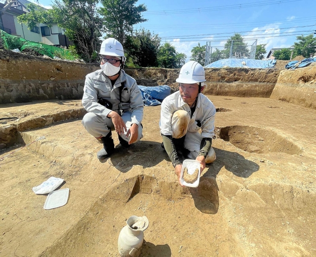 発掘された須恵器とすぐ近くで見つかった鉄器。背後には掘立柱の跡がある＝太子町吉福