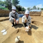発掘された須恵器とすぐ近くで見つかった鉄器。背後には掘立柱の跡がある＝太子町吉福