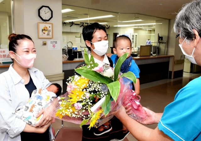 ８千人目の赤ちゃんとなった石原桃亜ちゃんを抱く母の紗耶さん（左）ら＝宍粟総合病院