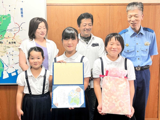 のじぎく賞を受けた可藤唯羽さん（前列中央）と心羽さん（同右）。両親と妹の前で誇らしげだった＝たつの市龍野町富永、たつの署