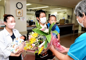 ８千人目の赤ちゃんとなった石原桃亜ちゃんを抱く母の紗耶さん（左）ら＝宍粟総合病院