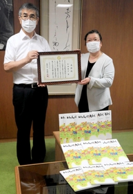絵本２００冊を寄贈し、感謝状を受け取る和田泰子さん（右）＝福崎町役場