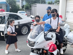 憧れの白バイにまたがらせてもらった可藤唯羽さんと心羽さんら姉妹＝たつの市龍野町富永、たつの署