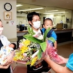 ８千人目の赤ちゃんとなった石原桃亜ちゃんを抱く母の紗耶さん（左）ら＝宍粟総合病院