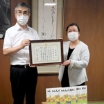 絵本２００冊を寄贈し、感謝状を受け取る和田泰子さん（右）＝福崎町役場