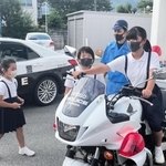 憧れの白バイにまたがらせてもらった可藤唯羽さんと心羽さんら姉妹＝たつの市龍野町富永、たつの署