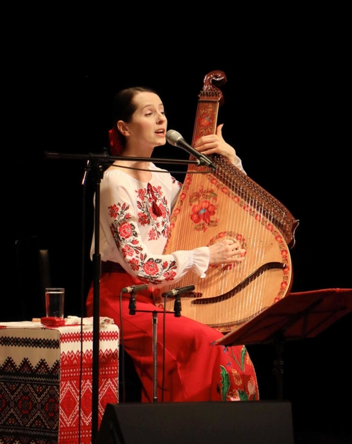 ウクライナ出身の歌手ナターシャ・グジーさんのチャリティーコンサート。民族楽器「バンドゥーラ」の弾き語りを披露した＝たつの市龍野町富永、赤とんぼ文化ホール