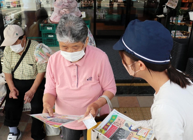 スーパーの買い物客にビラを配り、情報提供を呼びかける警察官＝たつの市新宮町新宮
