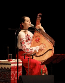 ウクライナ出身の歌手ナターシャ・グジーさんのチャリティーコンサート。民族楽器「バンドゥーラ」の弾き語りを披露した＝たつの市龍野町富永、赤とんぼ文化ホール
