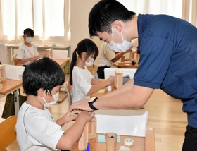 児童に工作を指導する甲斐翔太郎さん＝蔦沢小学校