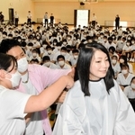 ４年半かけて伸ばした保杉香奈さんの髪の毛を切る生徒＝山崎高校