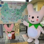 大型観光案内板の前でハートのまちをアピールする「カーミン」＝神河町鍛治